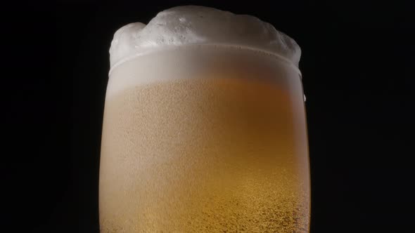 Glass of light beer on a black background. 
