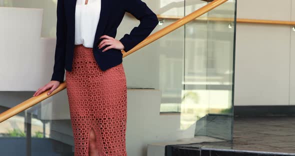 Businesswoman standing with hand on hip in stairs