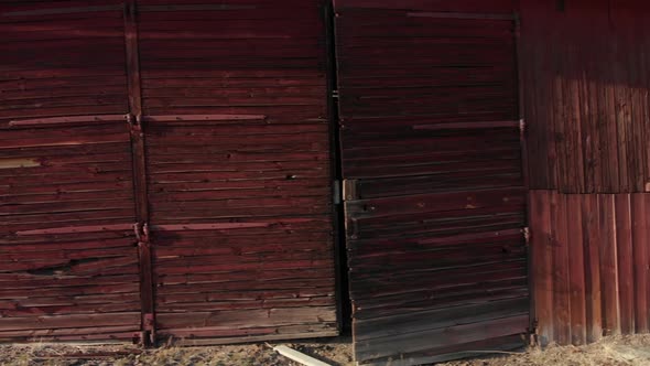 Moving left revealing an old abandoned red wooden house.