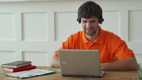 Smiling Male Call Center Operator Doing His Job with a Headset