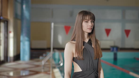 A Beautiful Woman is Standing Near a Large Pool