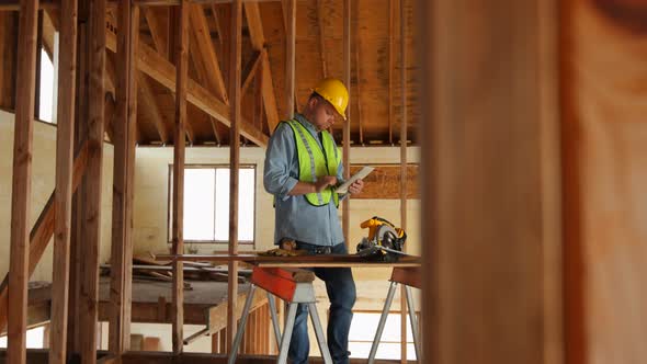 Construction worker using digital tablet on work site alt