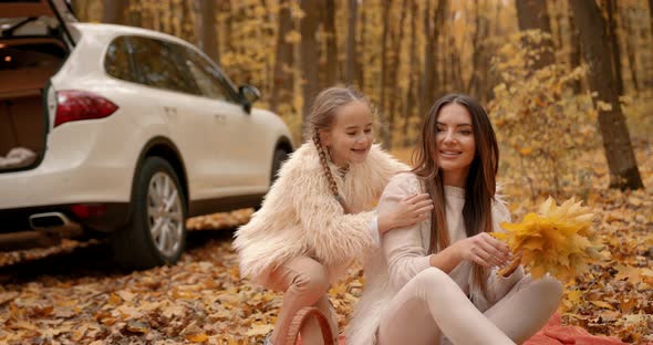 Little Daughter Hugging Mother in Autumn Forest