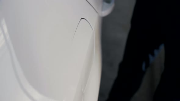 Man opens the gas tank flap of a car before refueling. Close-up