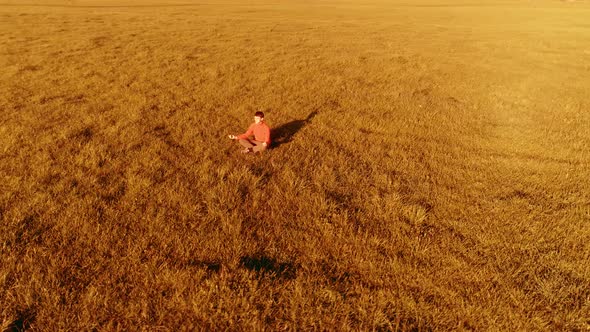 Low Altitude Radial Flight Over Sport Yoga Man at Perfect Green Grass. Sunset in Mountain