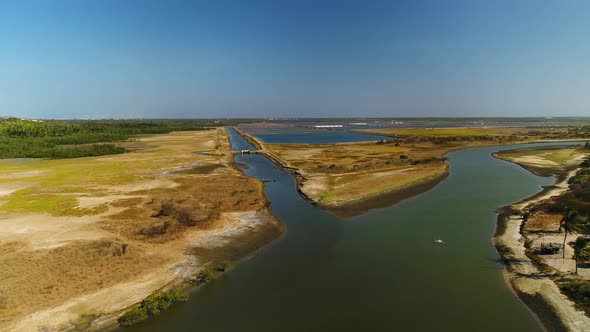 Aerial view of birds flying over a river near salt flat, Brazil.