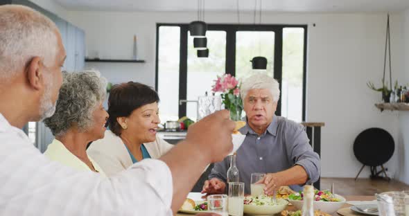 Happy senior diverse people having dinner at retirement home