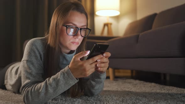 Woman Glasses Is Lying Floor Using Smartphone Evening