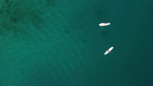 Aerial view of two women practicing stands up board, Losinj coastline, Croatia.