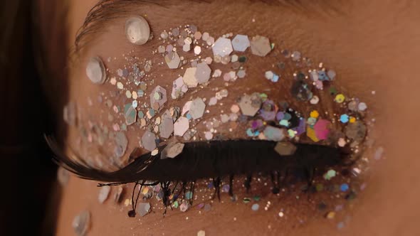 The Woman Opens and Closes Her Eye with Long Eyelashes and Sparkles. Close Up Macro Portrait. Slow