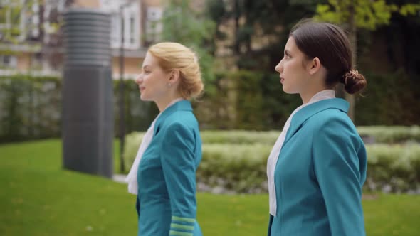 Side View of Two Confident Beautiful Caucasian Women Walking in City. Slim Young Elegant