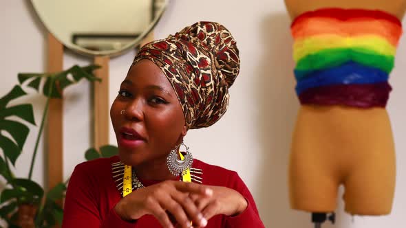 Tanzanian Woman with Snake Print Turban Over Hear Creating a Colorful Dress for Pride Parade in Her