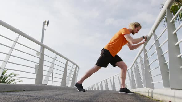 Sporty Caucasian man training on a bridge