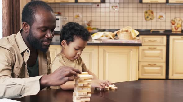 Father building up Jenga tower with his son