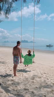 Couple Men and Woman at a Swing on the White Tropical Beach Phuket Thailand Naka Island