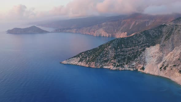 Aerial View of Kefalonia Coastline and Assos Village at Sunset Light and Low Clouds Moving