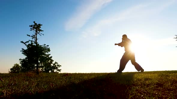 Silhouette of Fighter Training on Rising Sun Background, Unity With Nature