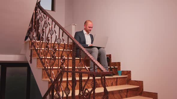 Company Manager Using Laptop Overworking on Stairs