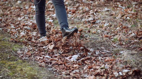 Woman Walking on Golden Leaves in Autumn