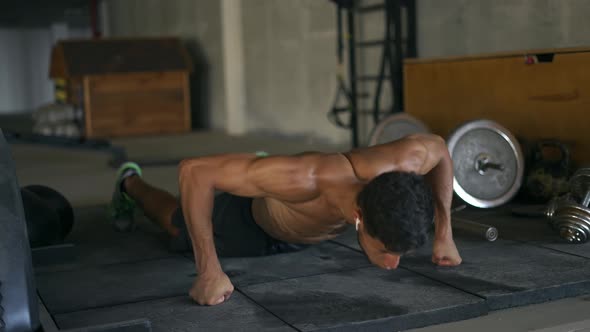 Concentrated Muscular Man Doing Pushups on Floor at the Underground Gym