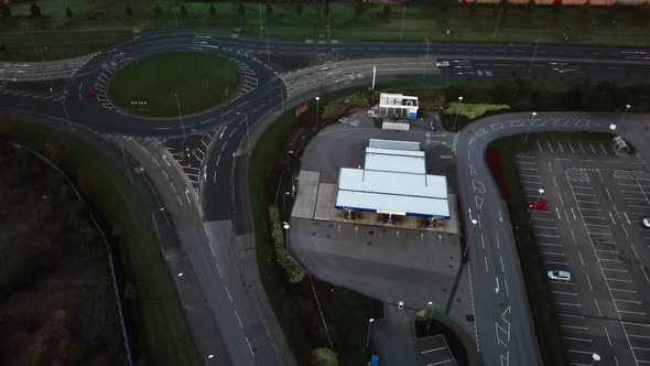 Aerial moving towards roundabout with minimal morning traffic.