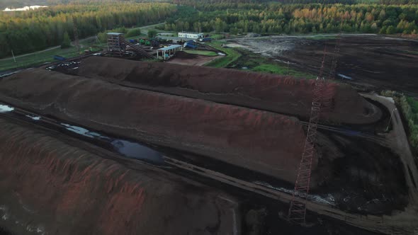 Piles of Lignin Stored in an Open Warehouse in a Wooded Area