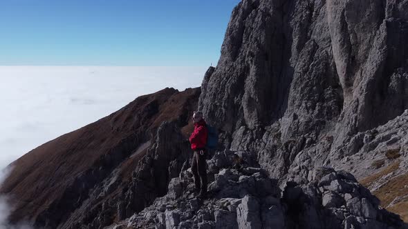 Hiker on mountain ridge, Lecco, Lombardy, Italy