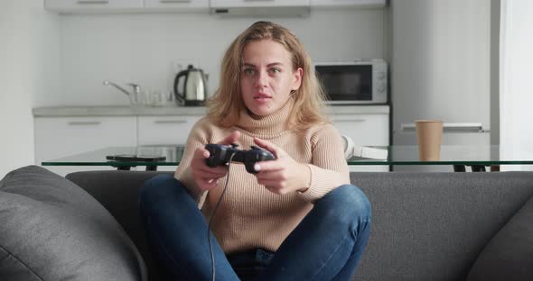 Blonde Woman Playing Games on the Smartphone Indoors