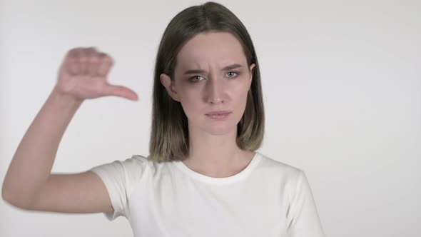 Young Woman Gesturing Thumbs Down on White Background