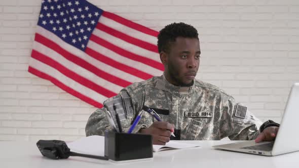 Afro-american Soldier in Uniform Working Seriously in Office