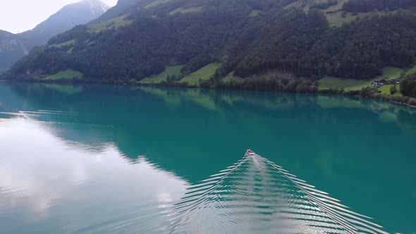 Luxury boat trip on serene Lungernersee lake in Swiss Alps, aerial view
