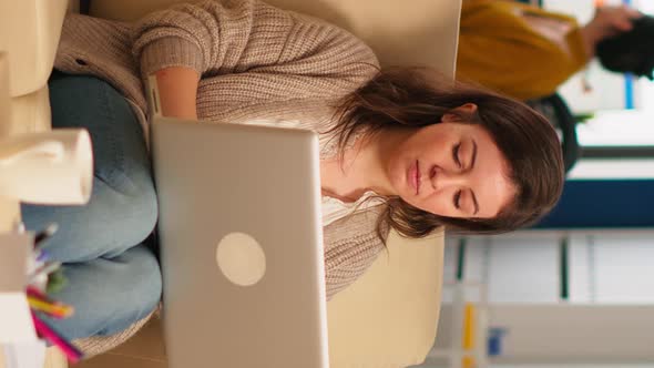 Young Woman Entrepreneur Sitting on Couch Looking at Camera