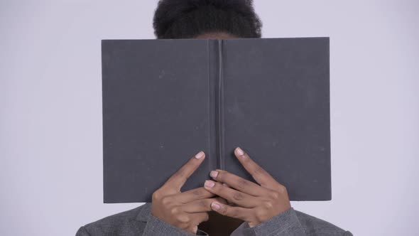 Face of Young Shy African Businesswoman Covering Face with Book