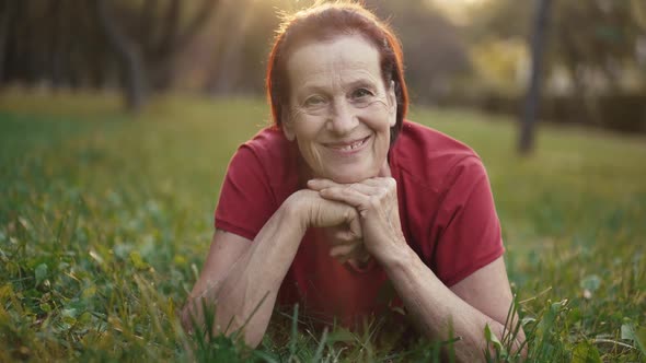 Elderly Happy Woman Lying on the Grass