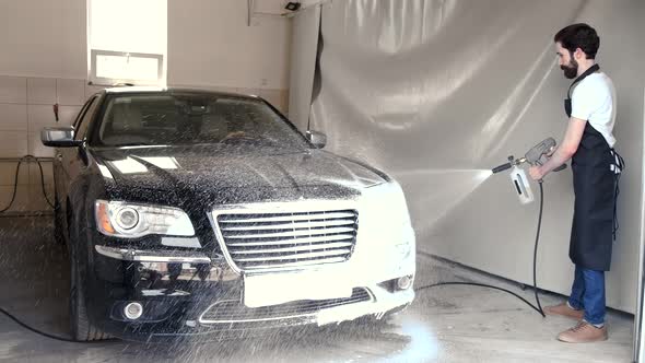 Man Washing His Car in a Garage