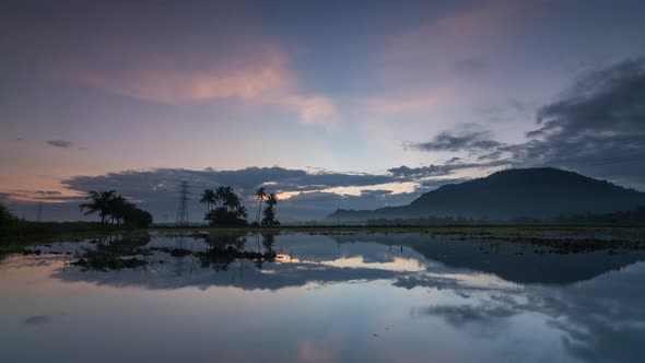 Timelapse reflection of coconut and hill with beautiful colorful sky.