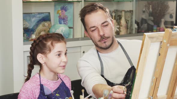 Cute Little Girl Watching Her Father Artist Painting a Picture