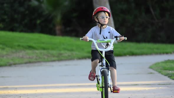 A boy riding a bike in a park.