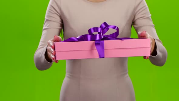 Girl Holding Out a Box with a Gift. Close Up