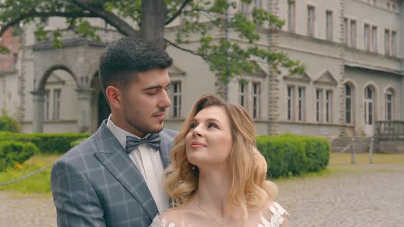 Newlywed Wedding Couple Walking in the Park. Two Young People in Love Meet Each Other's Eyes