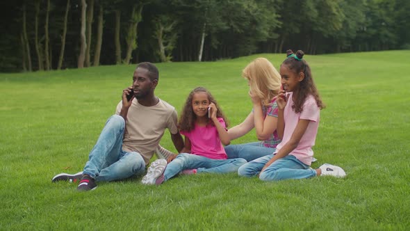 Multiethnic Family Busy with Smart Phones Outdoors