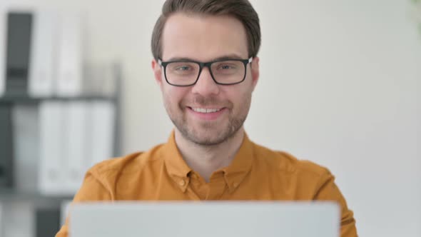 Close Up of Thumbs Up By Young Man with Laptop