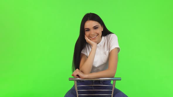 Gorgeous Happy Teenage Girl Sitting on a Chair Smiling To the Camera