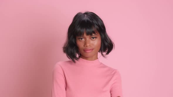 Young Asian Woman Shakes Head Showing Denial Disagreement Stands in Pink Studio