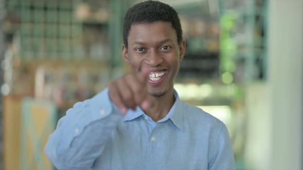 Portrait of Young African Man Pointing Finger and Inviting