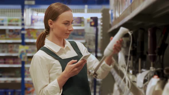 Redhaired Customer Examines Blender in Supermarket Closeup