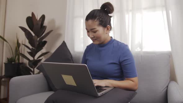 Businesswoman authentic shot using a laptop to work from home happily