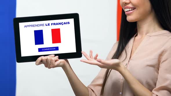 Learn French Language App on Tablet Screen in Female Hand, Online Education