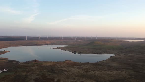 Lakes of Scottish moorland and wind farm at twilight. Drone view