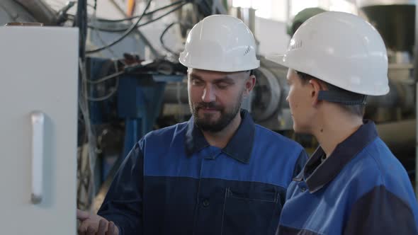  Male Supervisor Talking to Female Factory Worker